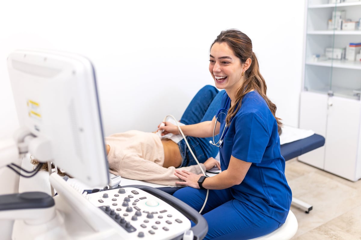 Médica realizando elastografía hepática por ultrasonido a una paciente